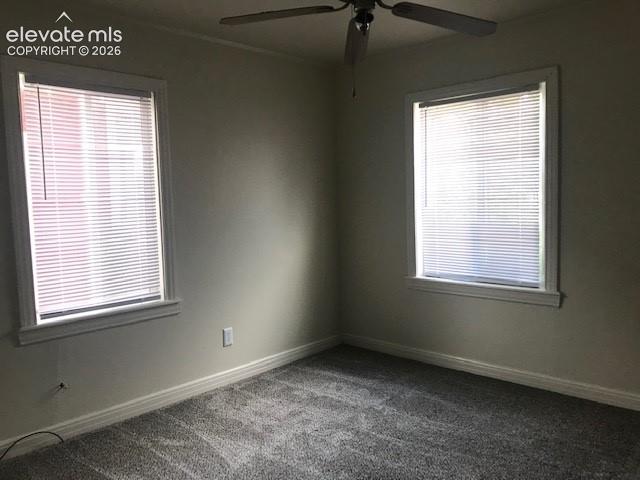 Image 10 of 18: Plush gray carpeting, dual windows with blinds, and a ceiling fan with inte