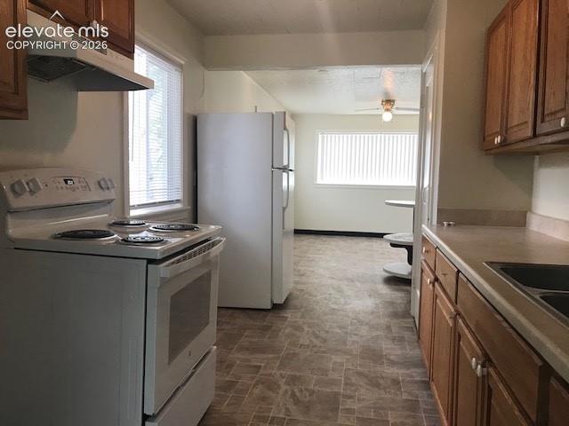 Image 4 of 18: Kitchen featuring light wood-finish cabinetry, white appliances, and a dura