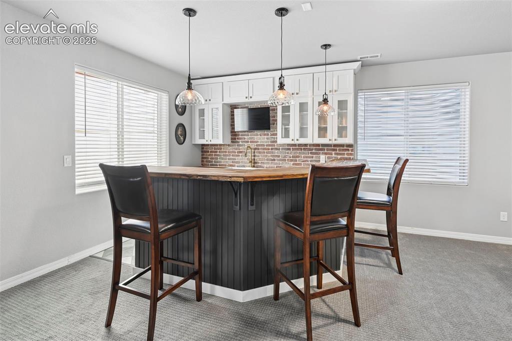 Image 28 of 50: Custom designer wetbar w/ real brick accent wall, custom cabinetry, mini-fr