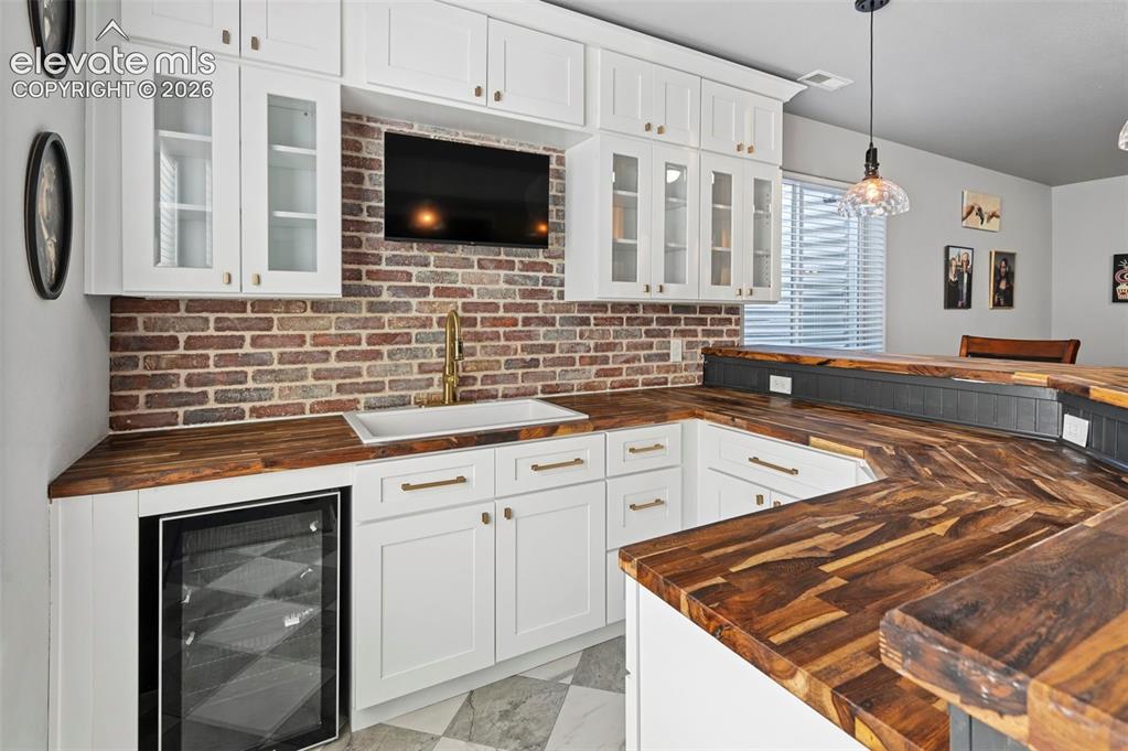 Image 29 of 50: Custom designer wetbar w/ real brick accent wall, custom cabinetry, mini-fr