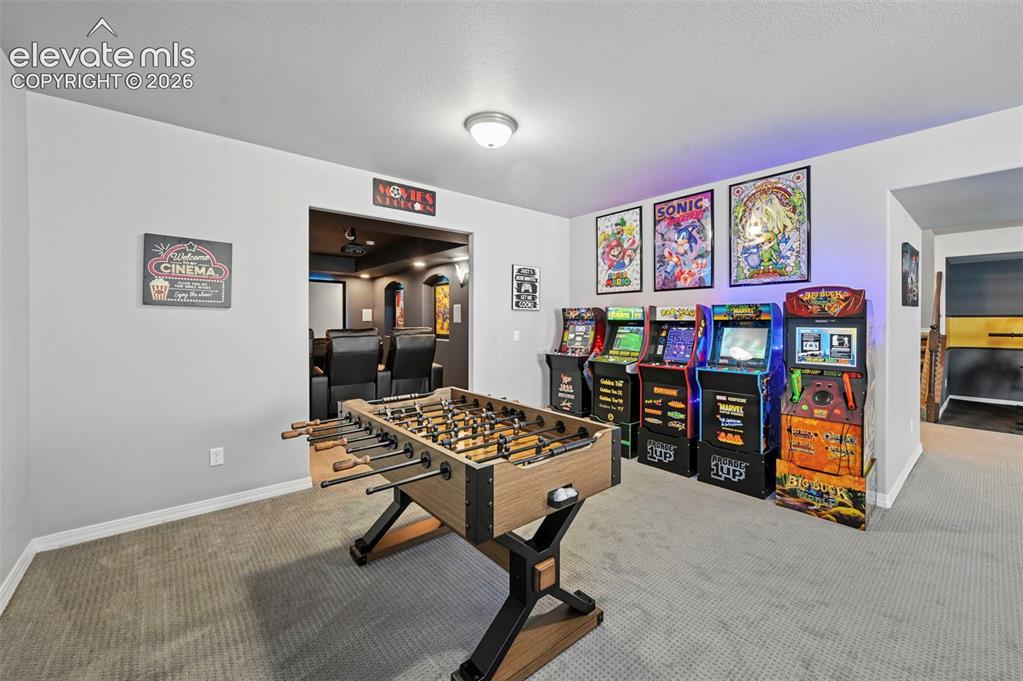 Image 31 of 50: Basement game room, with designer wetbar, arcade area, workout/gym area, an