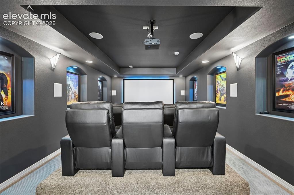 Image 32 of 50: True dedicated theater room w/ screen, elevated seating,  recessed alcoves,