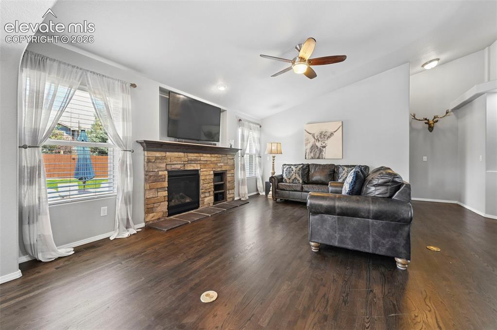 Image 6 of 50: Living room w/ gorgeous hardwoods, cozy fireplace and more!