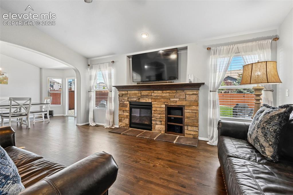 Image 7 of 50: Living room w/ gorgeous hardwoods, cozy fireplace, and more!  Overlooking d