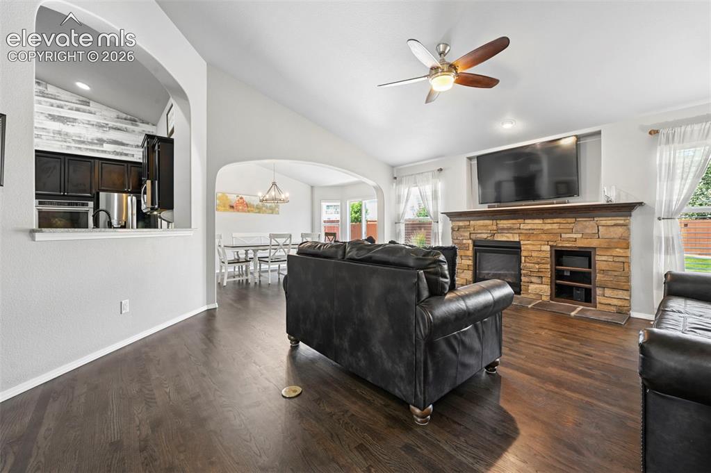 Image 9 of 50: Living room w/ gorgeous hardwoods, cozy fireplace, and more!  Overlooking d