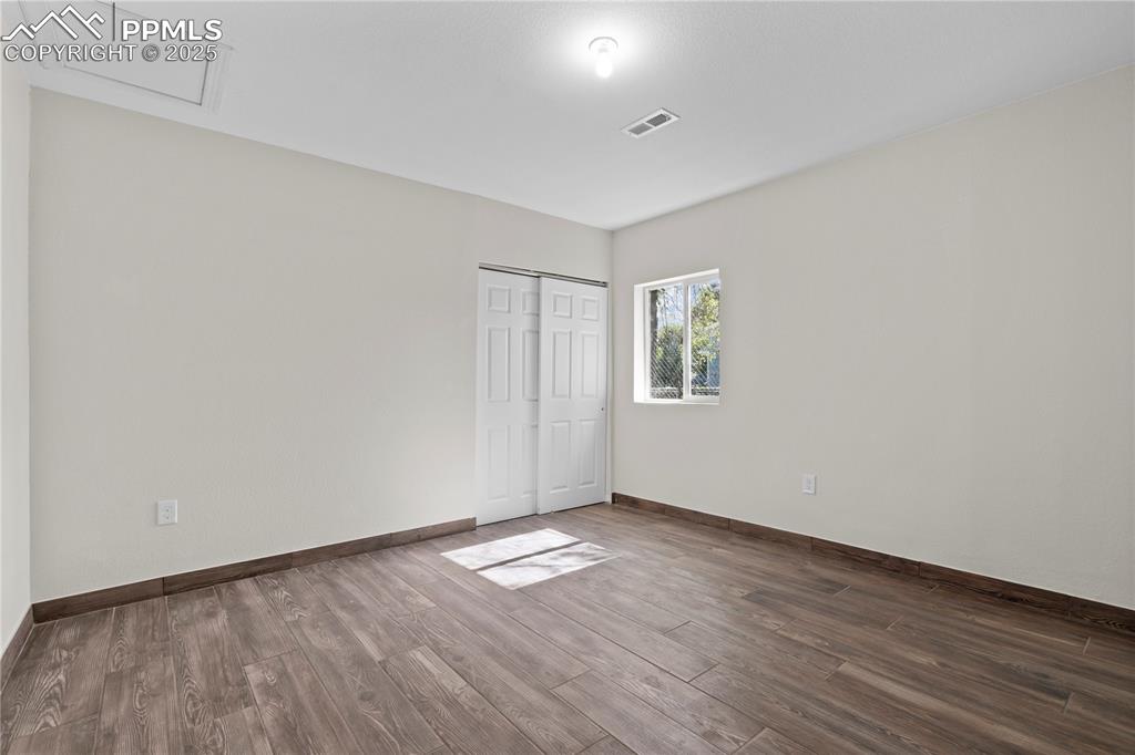 Image 10 of 35: Unfurnished bedroom featuring wood finished floors and a closet