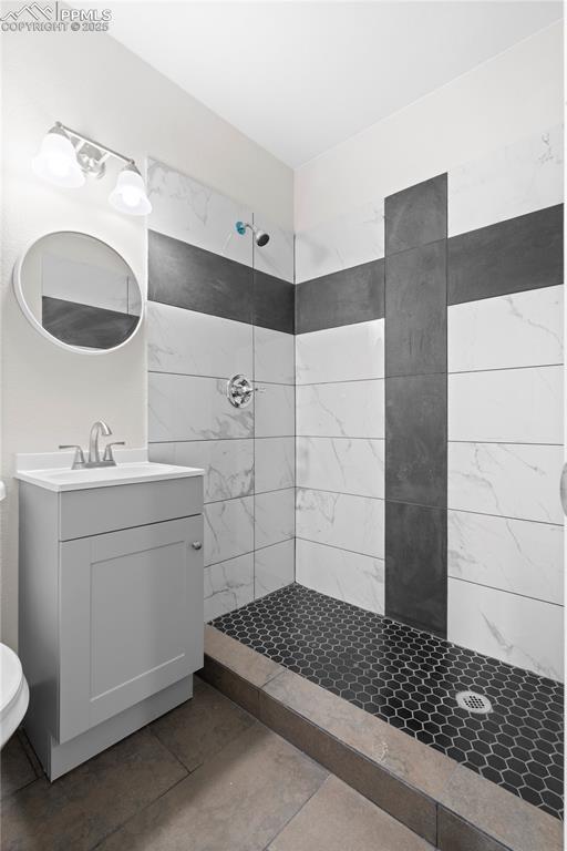 Image 11 of 35: Bathroom with tiled shower and vanity