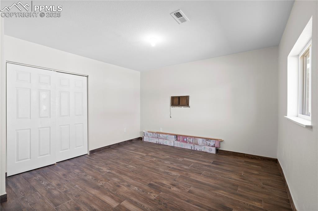 Image 15 of 35: Unfurnished bedroom with wood finished floors and baseboards