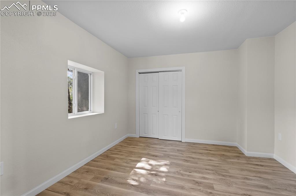 Image 16 of 35: Unfurnished bedroom with light wood-style flooring and a closet