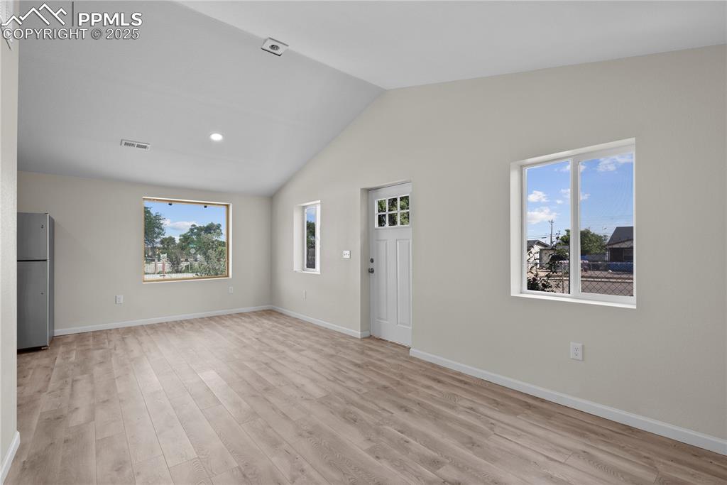 Image 18 of 35: Unfurnished living room with light wood-style flooring, plenty of natural l