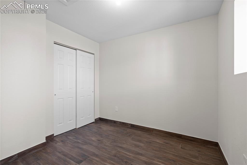 Image 22 of 35: Unfurnished bedroom featuring dark wood-style floors and a closet