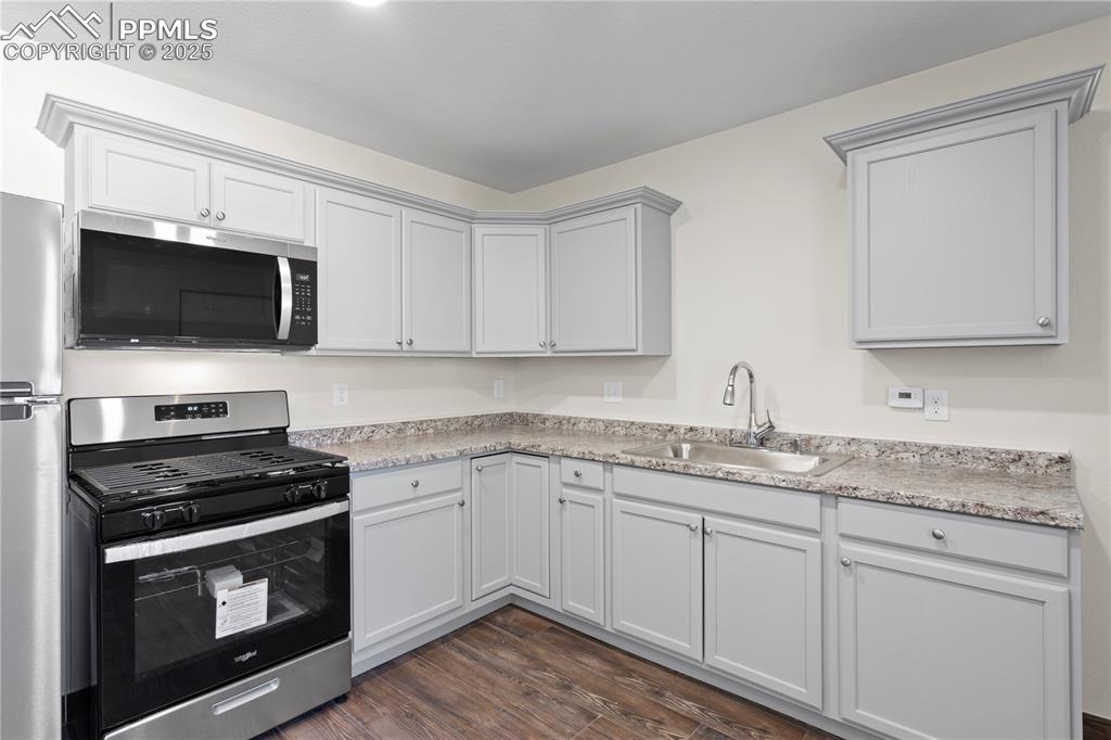 Image 29 of 35: Kitchen featuring appliances with stainless steel finishes, light counterto