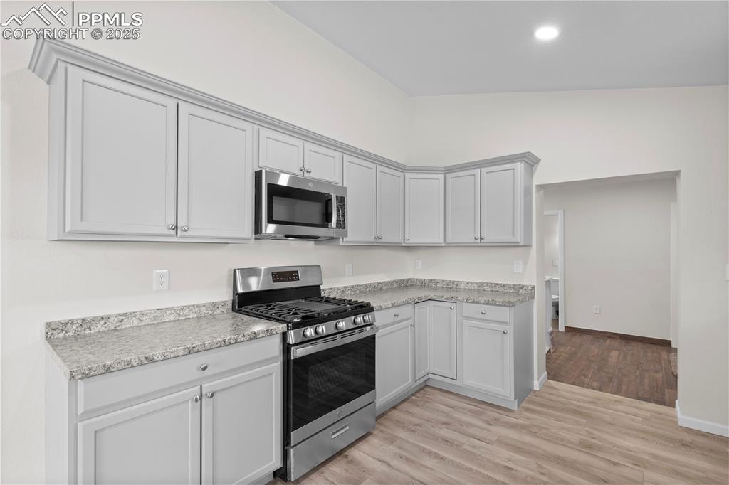 Image 3 of 35: Kitchen featuring stainless steel appliances, light countertops, light wood