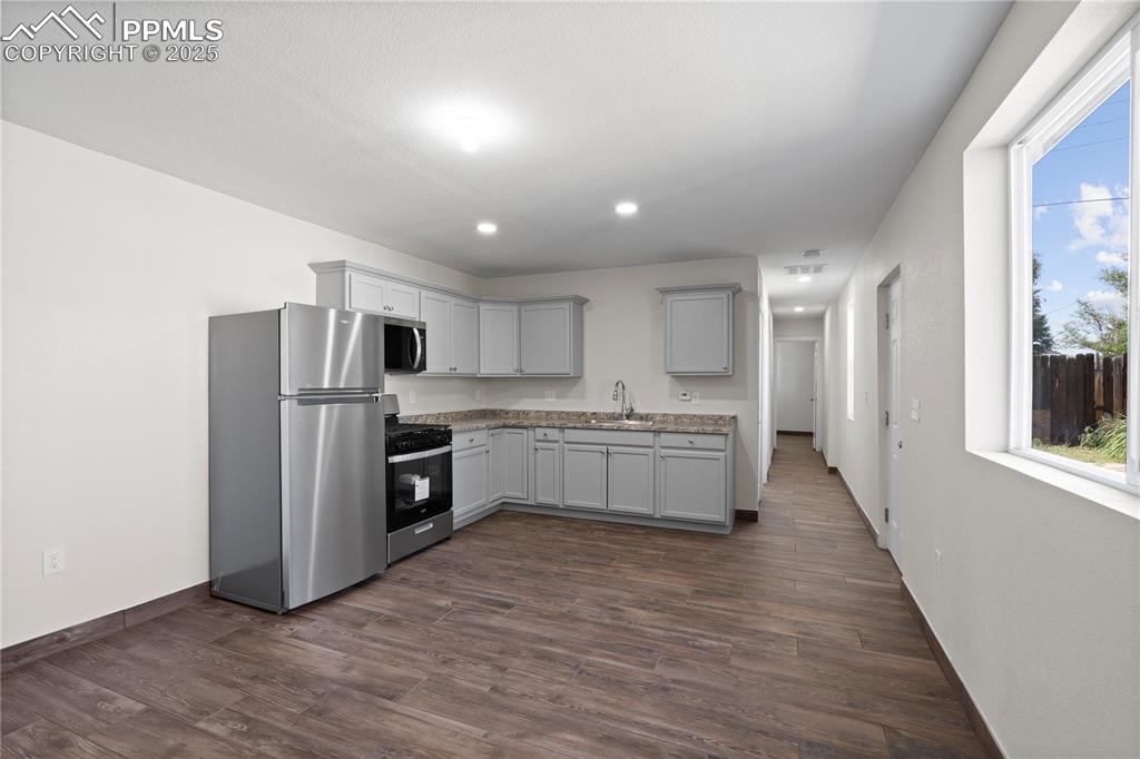 Image 31 of 35: Kitchen featuring appliances with stainless steel finishes, dark wood-style