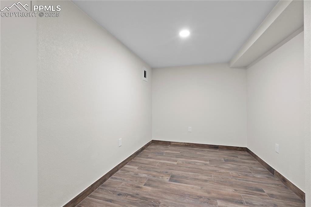 Image 7 of 35: Unfurnished room with wood finished floors and baseboards