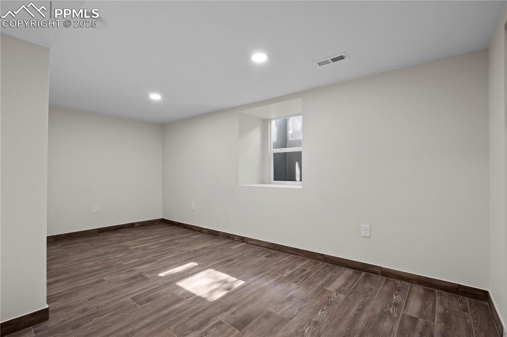 Image 9 of 35: Spare room with dark wood-style flooring, recessed lighting, and a smoke de