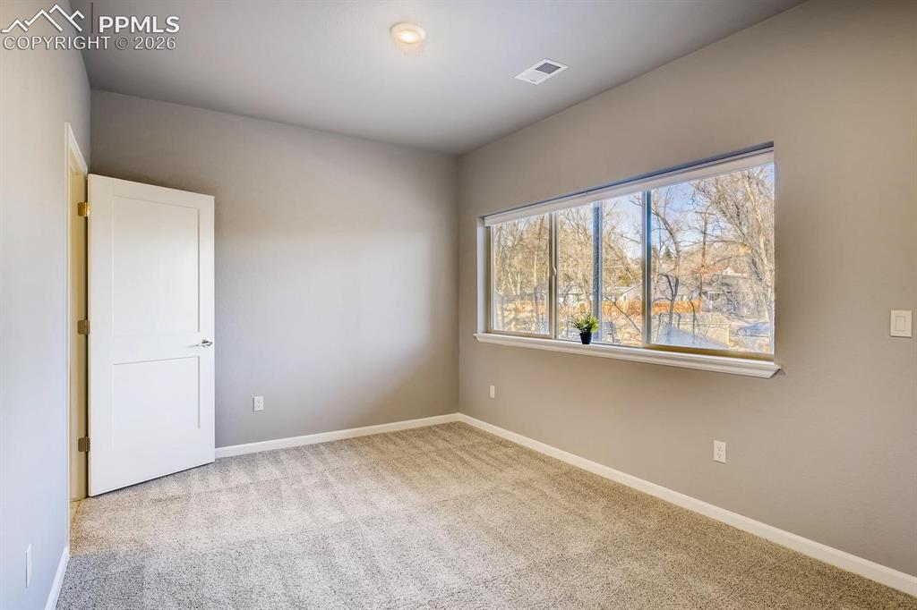 Image 22 of 28: First floor bedroom with en-suite bath and private walkout to patio