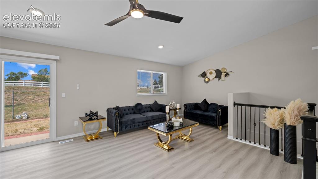 Image 10 of 48: Spacious living area featuring light wood-finish flooring and neutral wall
