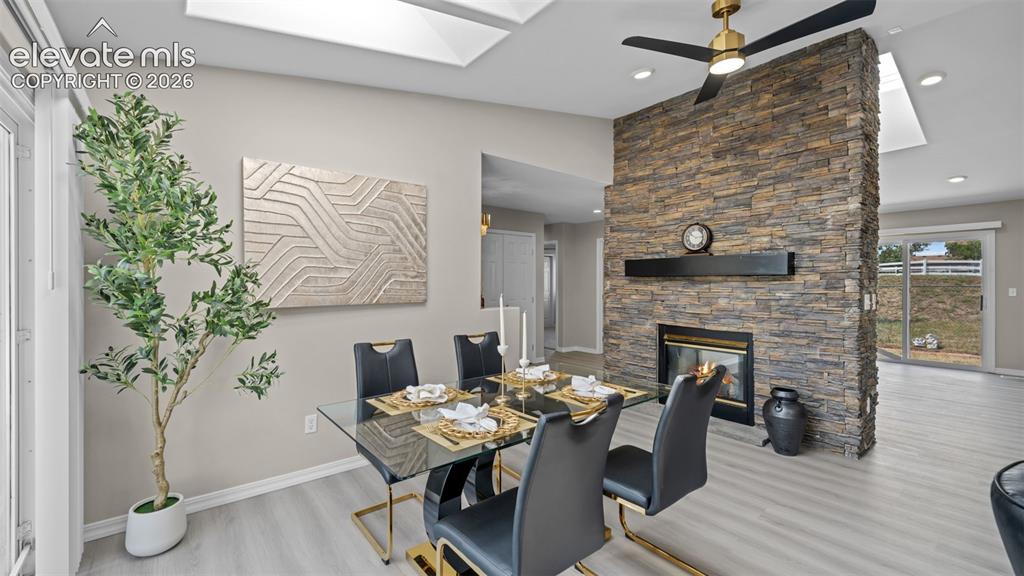 Image 18 of 48: Dining area featuring a stone accent wall with a built-in fireplace, a ceil