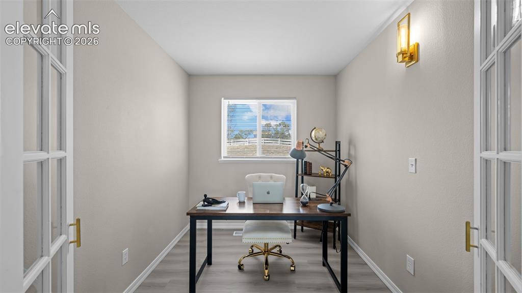 Image 20 of 48: Dedicated room featuring French doors with glass panels, wood-finish floori