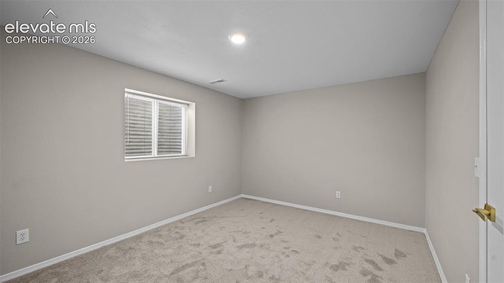 Image 31 of 48: Carpeted room featuring neutral wall paint, a window with blinds, recessed