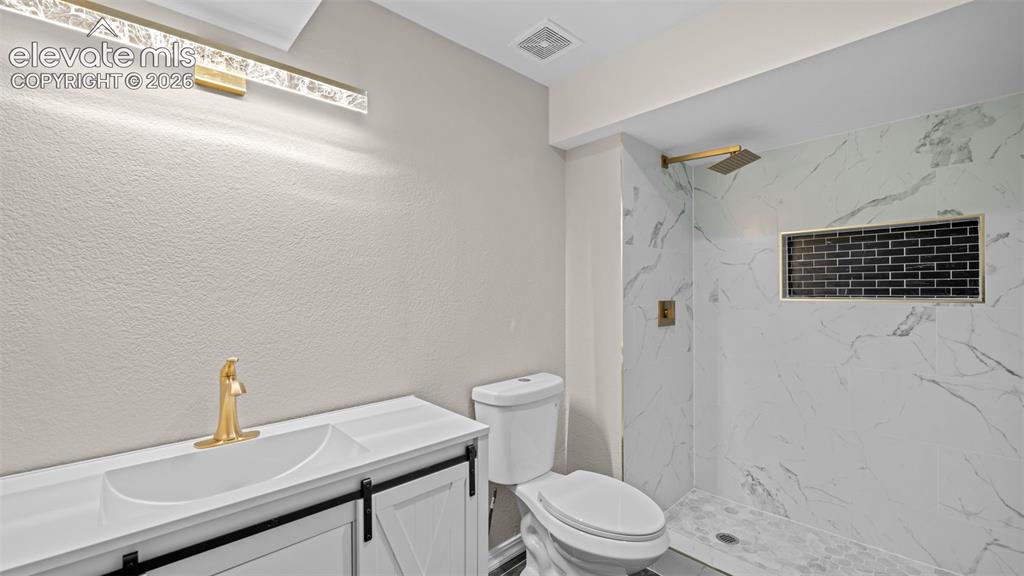 Image 32 of 48: Bathroom featuring a standing shower with white marble-style tile, a black