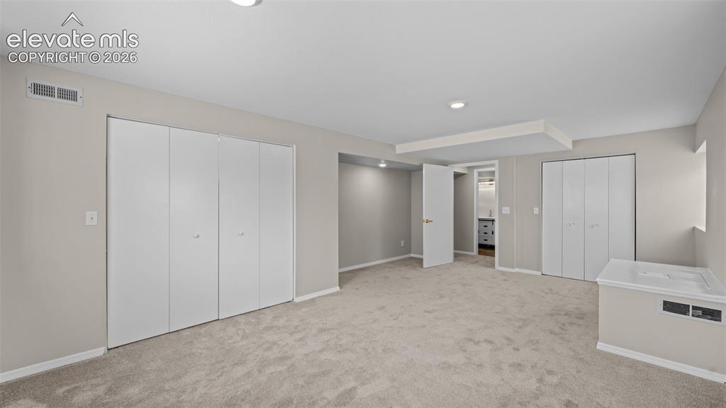Image 34 of 48: Spacious room featuring neutral carpeting, recessed lighting, and multiple