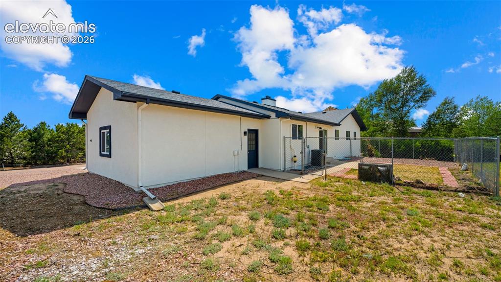 Image 37 of 48: Exterior featuring a light-colored stucco finish, dark-trimmed windows, a d