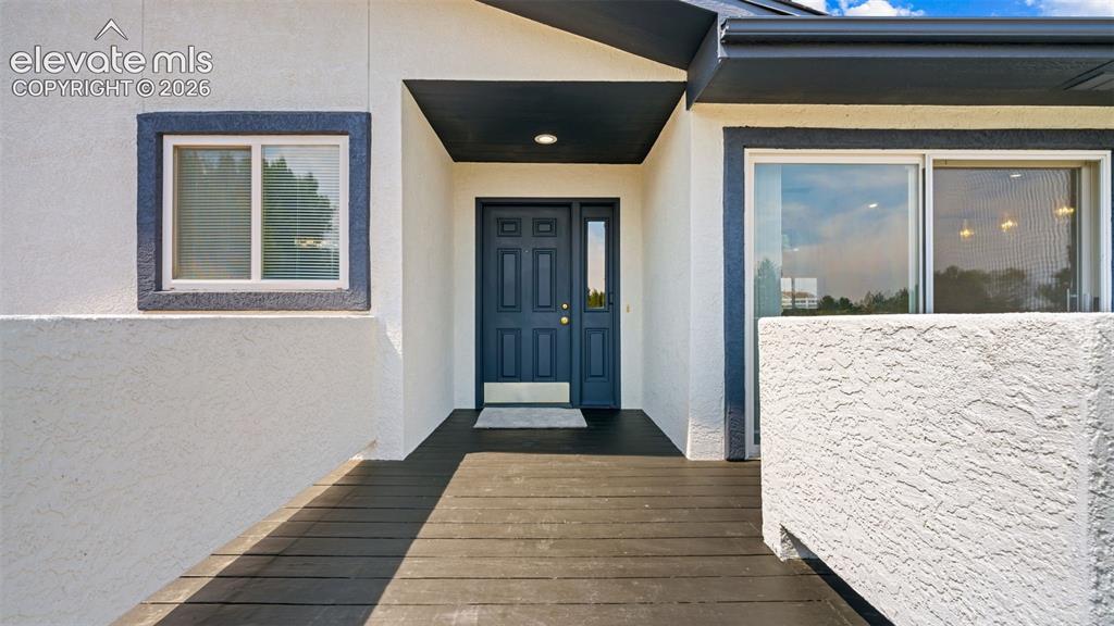 Image 4 of 48: Entryway featuring a dark blue paneled door with sidelight, overhead recess