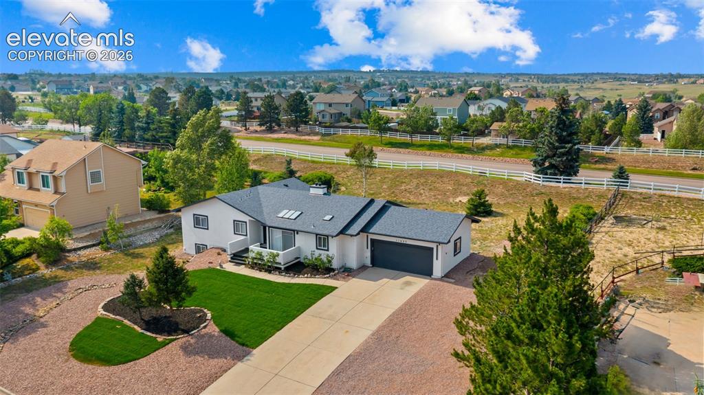 Image 40 of 48: Contemporary ranch-style residence featuring a dark gray shingled roof, lig