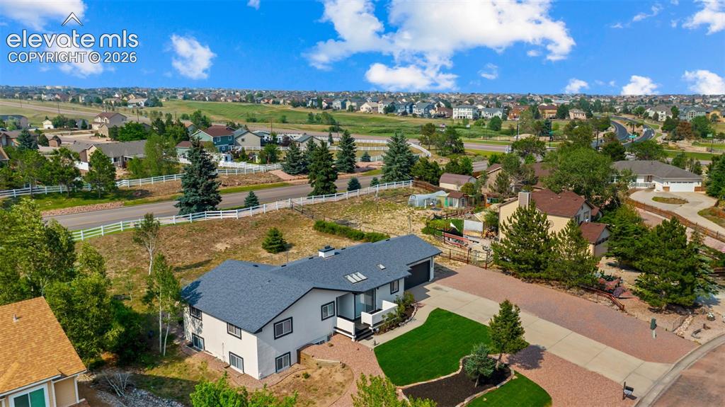 Image 41 of 48: Aerial perspective showcasing a light-colored stucco exterior with dark-fra