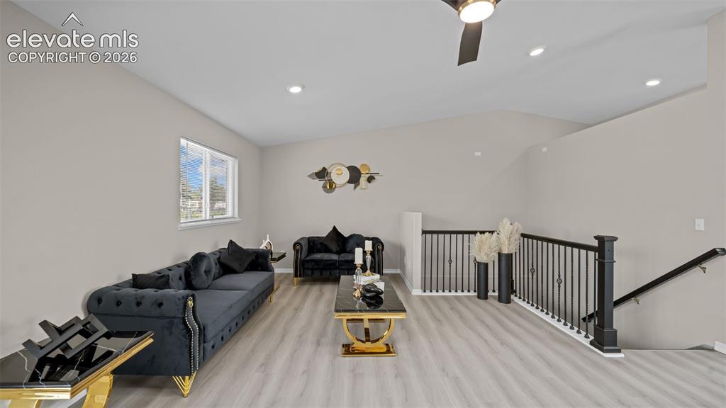Image 9 of 48: Spacious living area featuring vaulted ceilings, light wood-finish flooring