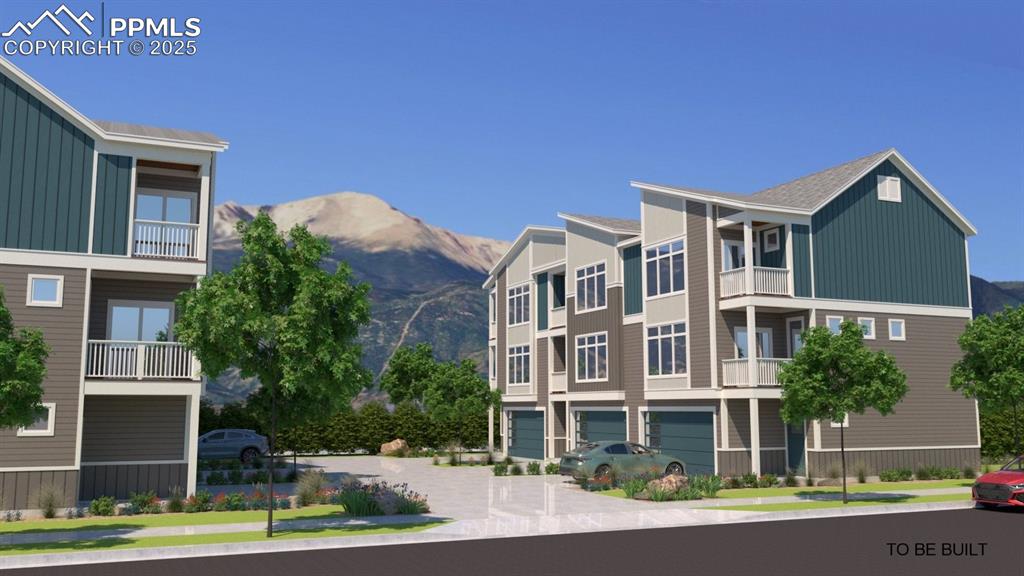 Image 2 of 3: View of property featuring a garage, a mountain view, and driveway