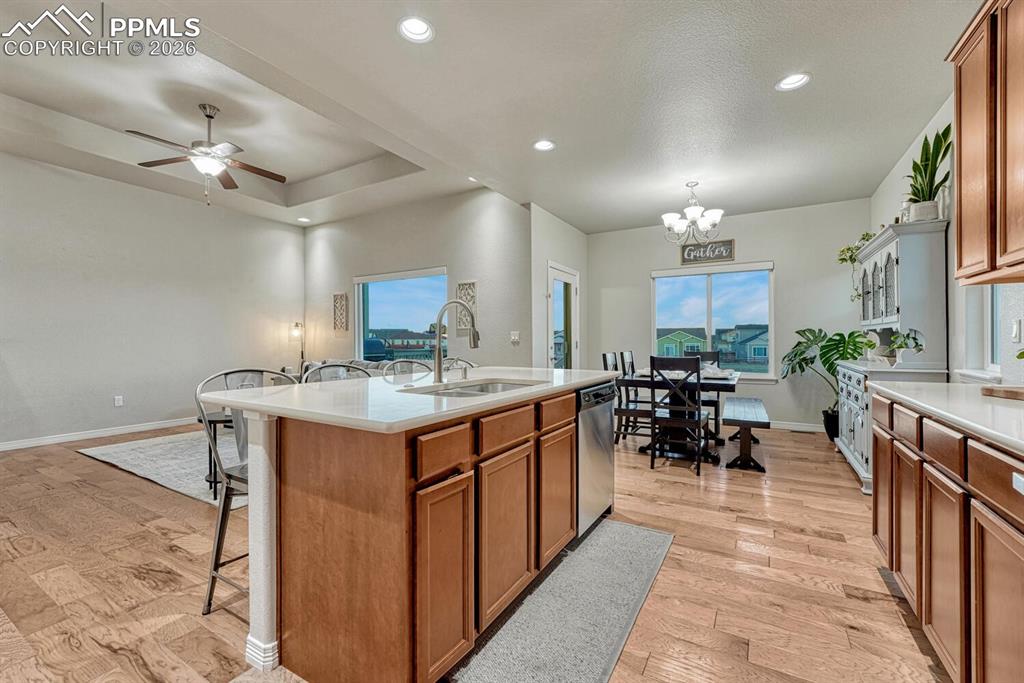 Image 11 of 46: Kitchen featuring brown cabinetry, a kitchen breakfast bar, recessed lighti