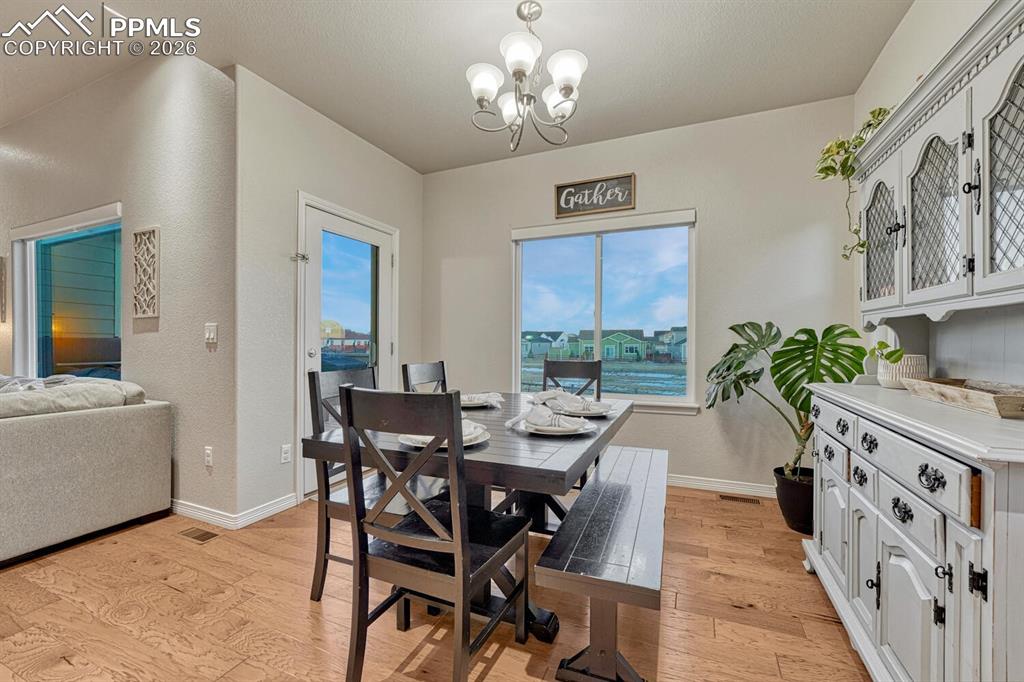 Image 13 of 46: Dining area with light wood-style floors and a chandelier