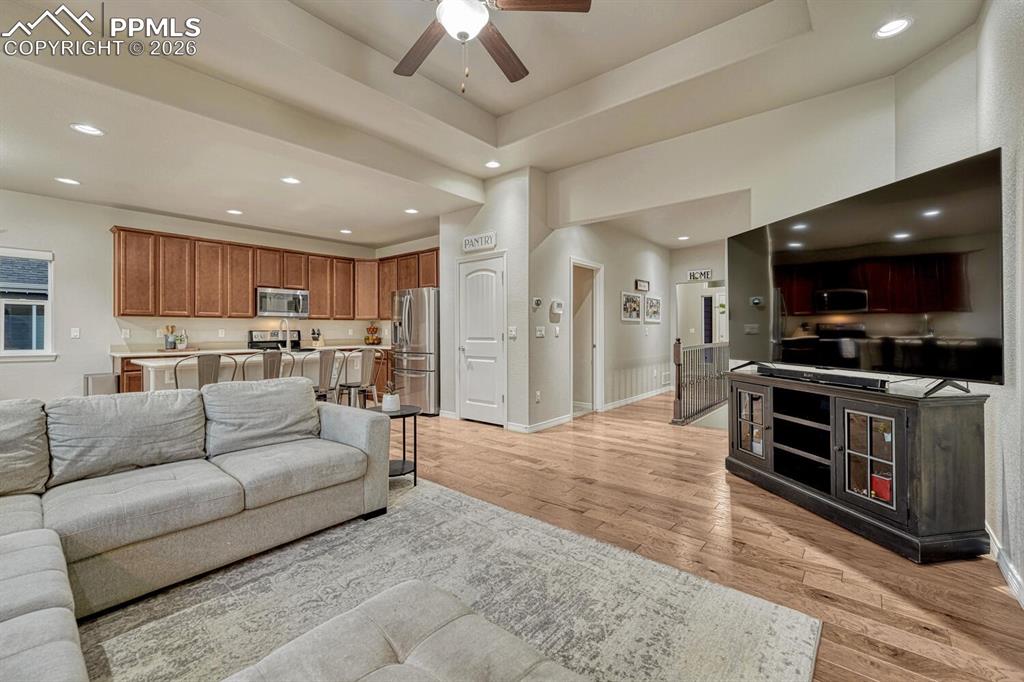 Image 15 of 46: Living area featuring a ceiling fan, light wood-style floors, recessed ligh