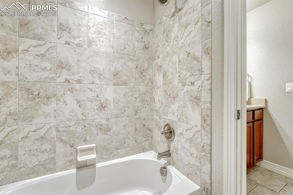 Image 30 of 46: Full bathroom featuring a textured wall, bathing tub / shower combination, 
