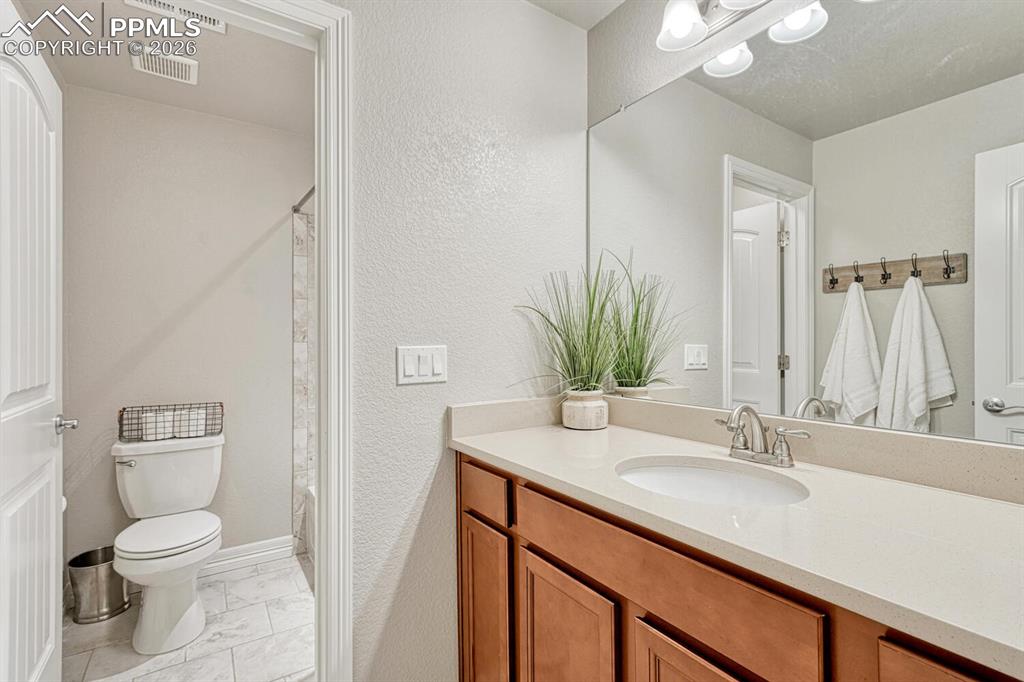 Image 31 of 46: Full bathroom featuring vanity, light marble finish floors, a shower with c