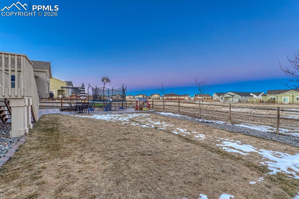 Image 39 of 46: Yard at dusk with a residential view