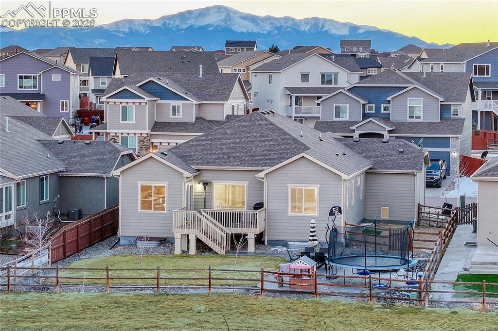 Image 42 of 46: Rear view of property with a fenced backyard, a trampoline, roof with shing