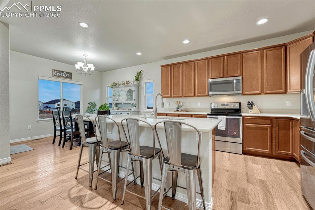 Image 8 of 46: Kitchen featuring appliances with stainless steel finishes, brown cabinetry