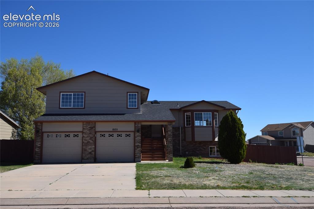 Image 1 of 45: Two-story residence featuring a two-car garage with stone accents, a multi-