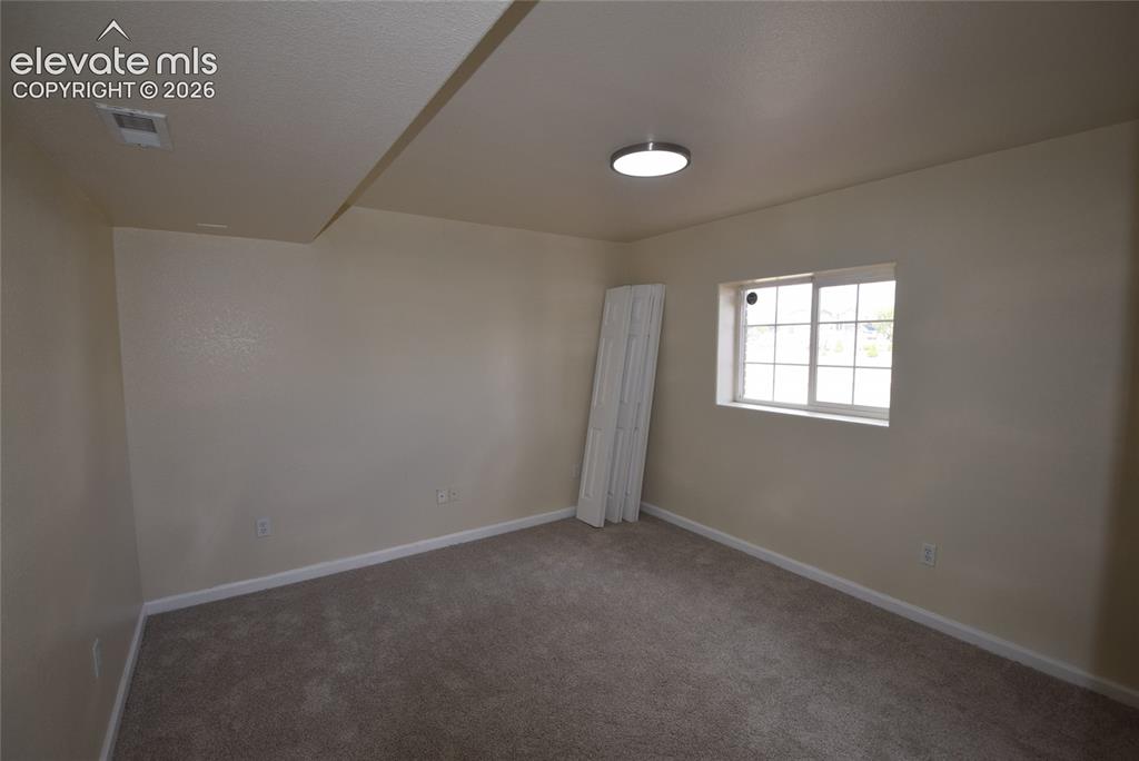Image 16 of 45: Carpeted interior room with neutral-toned walls