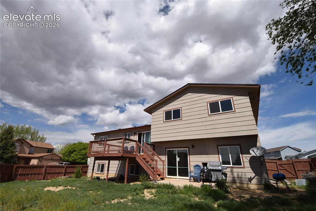 Image 2 of 45: Two-story residence featuring light-colored horizontal siding and a dark ro