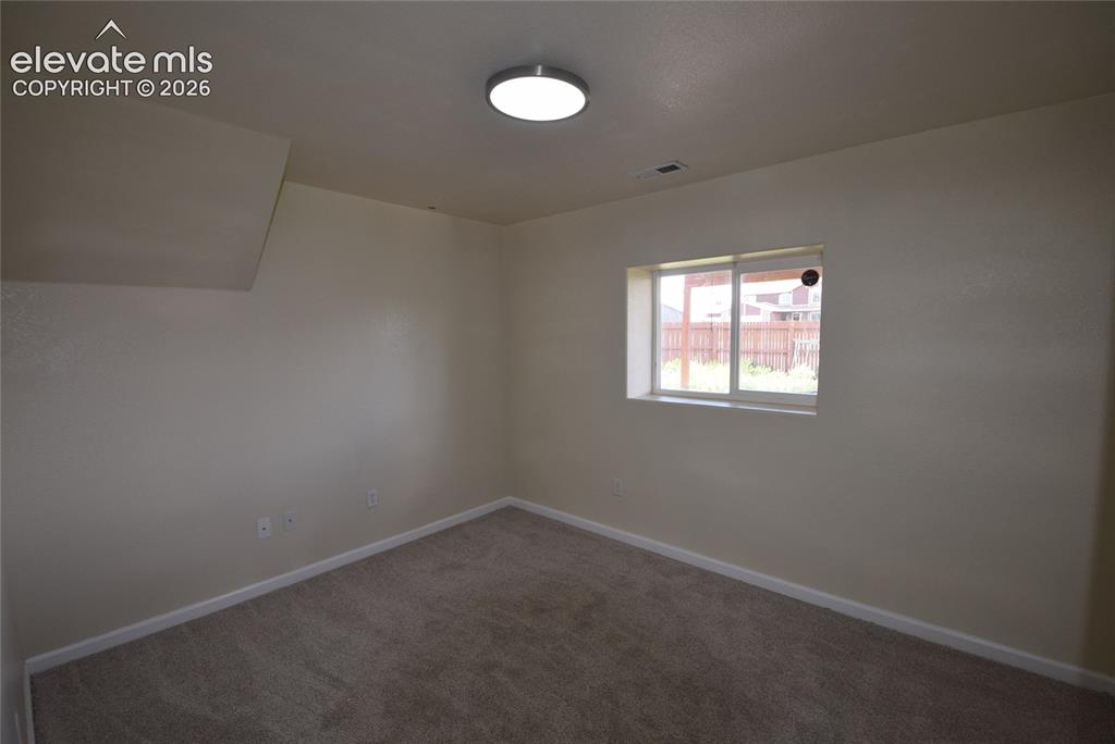 Image 20 of 45: Neutral tone walls with an accent window, featuring a ceiling-mounted light