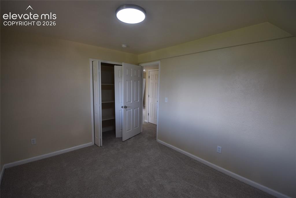 Image 21 of 45: Carpeted room featuring a ceiling-mounted light fixture, bi-fold closet doo