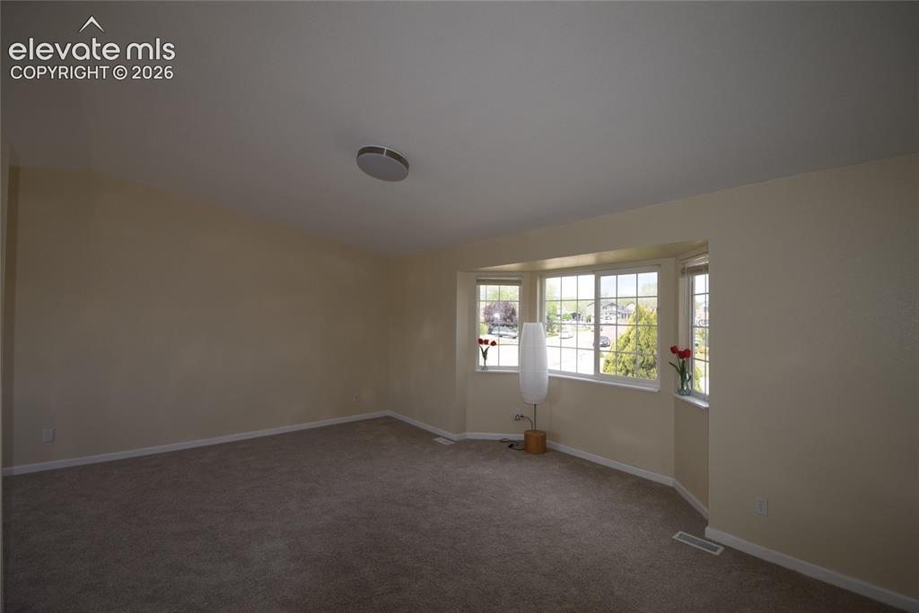 Image 23 of 45: Carpeted room featuring a bay window with multiple panes, neutral wall colo