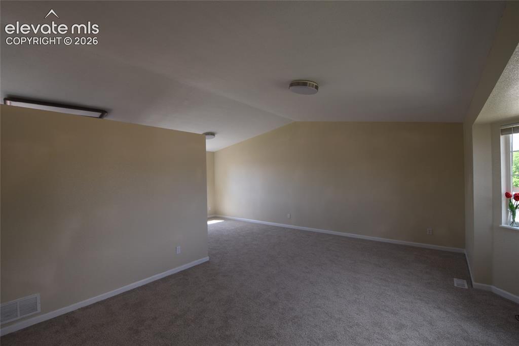 Image 24 of 45: Spacious interior room with neutral-toned walls