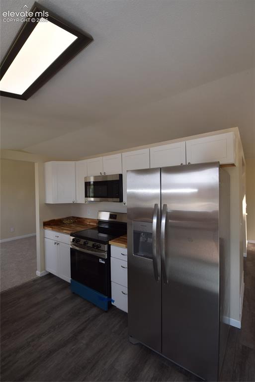 Image 26 of 45: Kitchen featuring stainless steel appliances, white cabinetry, wood-finish 