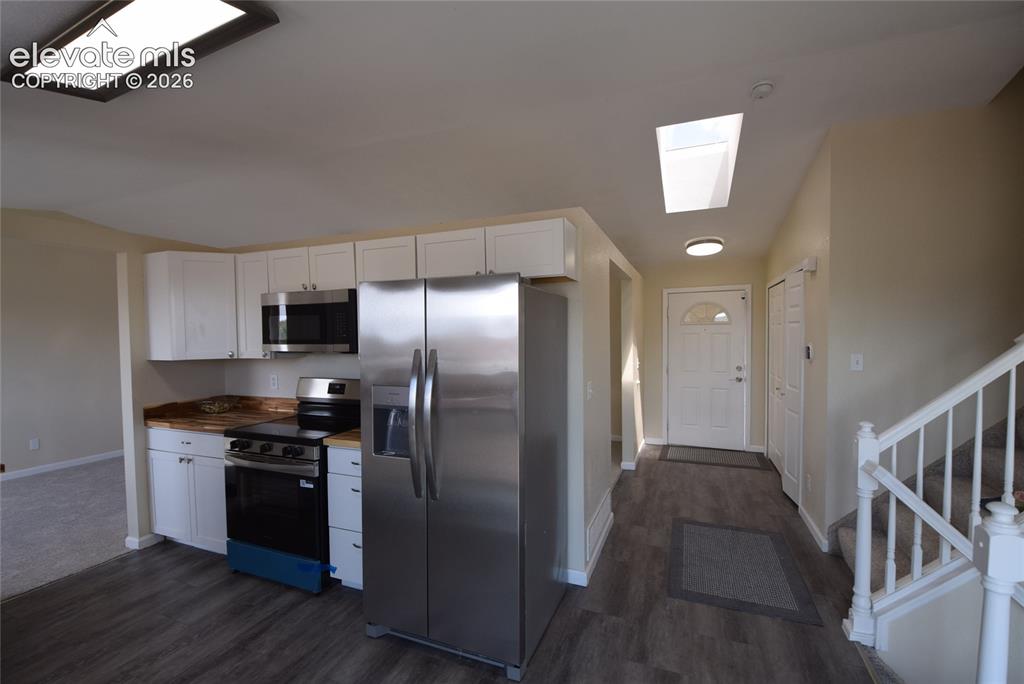 Image 27 of 45: Well-appointed kitchen featuring stainless steel appliances, white cabinetr